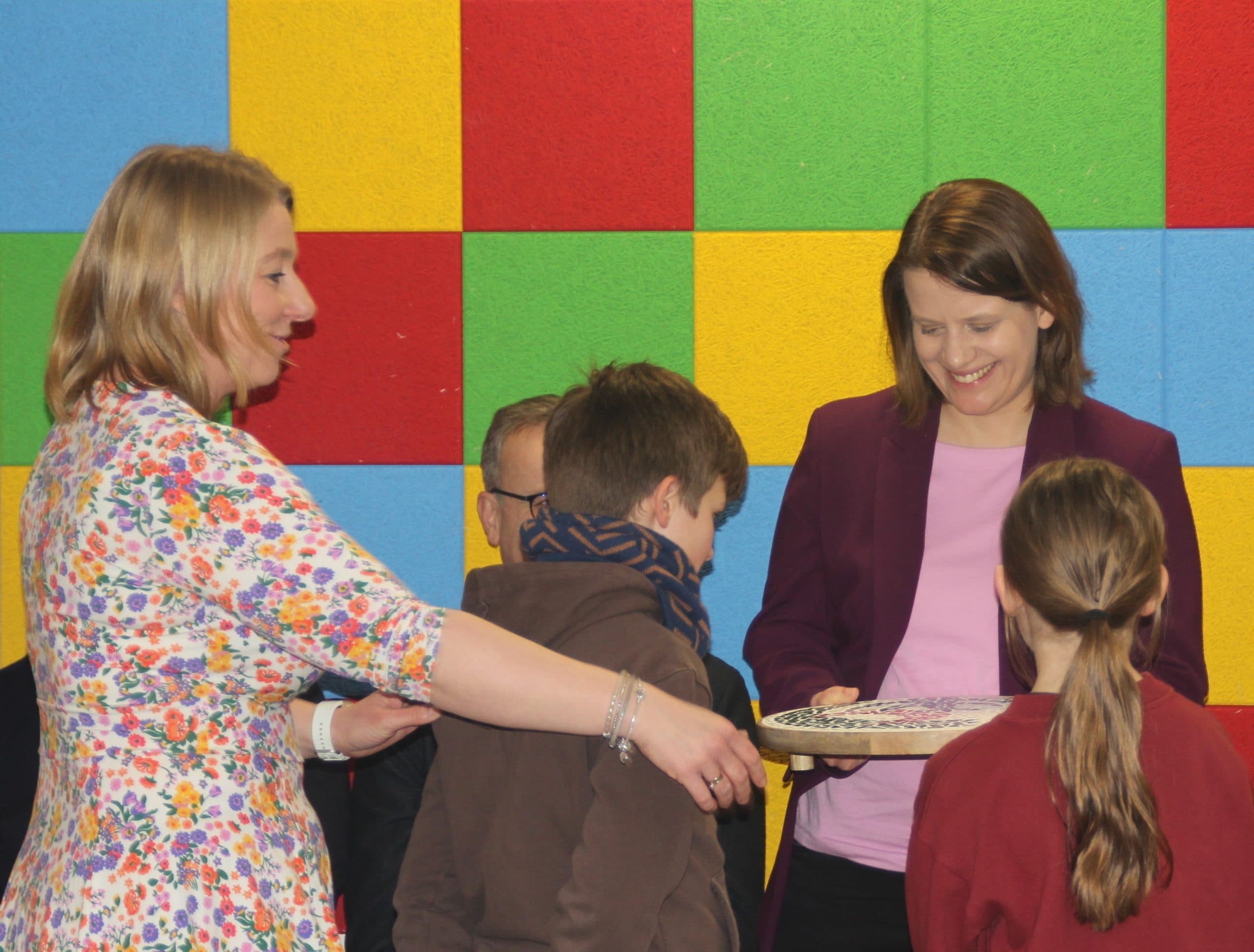 Besuch Ministerin Kinder der Drei-Religionen-Schule überreichen zusammen mit der stellvertretenden Schulleiterin Sandra Wilhelm (links) ein Mosaik mit dem Schullogo an Kultusministerin Julia Willie Hamburg (rechts)