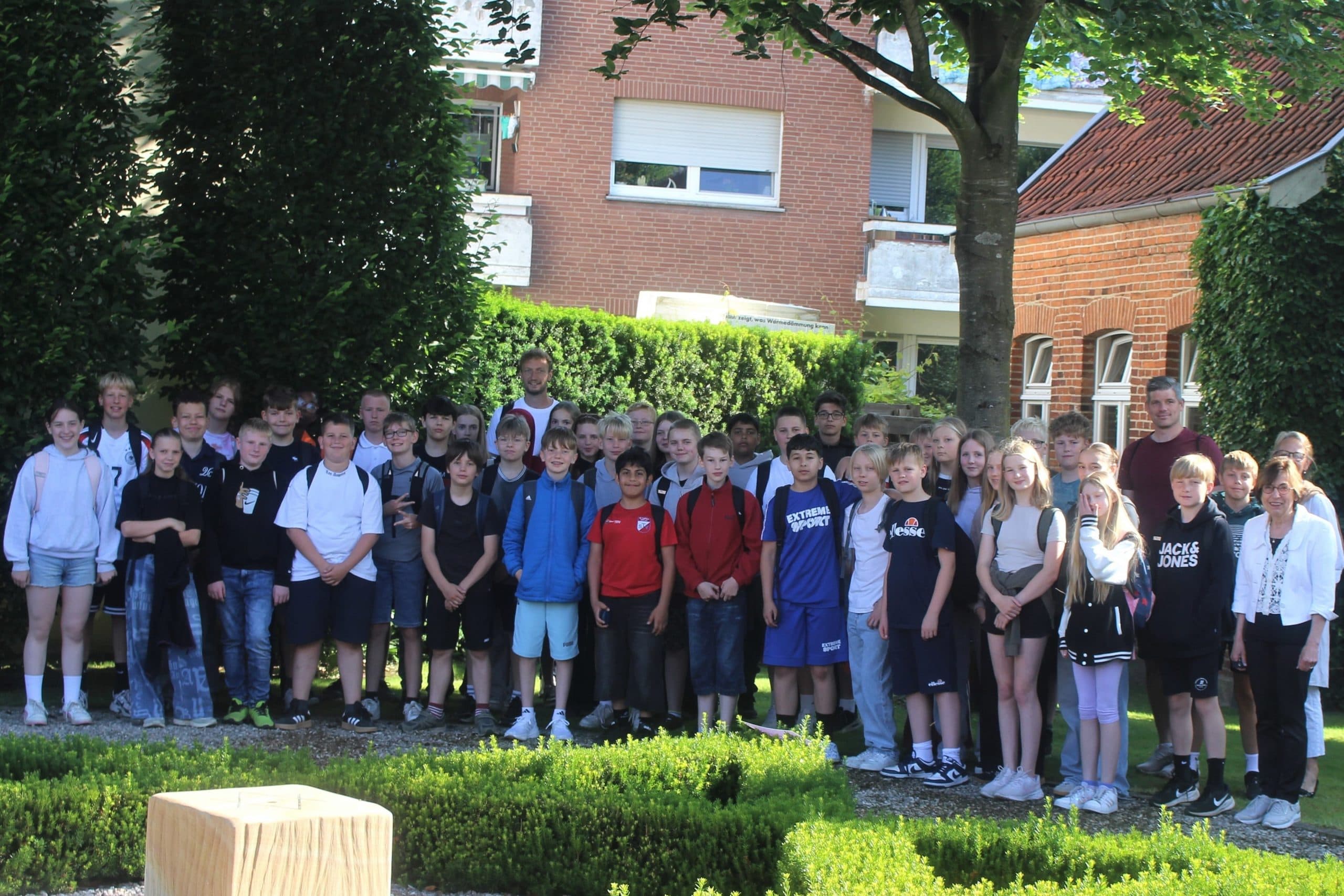 Johannesschule FJC Meppen Die Klassen 6d und 6e der Johannesschule Meppen mit den Lehrern Robert Bartling (li) und Klaus Lammers vor dem Gedenkort Jüdische Schule. Rechts Anne Gottschalk, daneben Angela Prenger